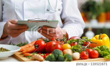 Fresh vegetables on cutting board with chef holding clipboard 116521671