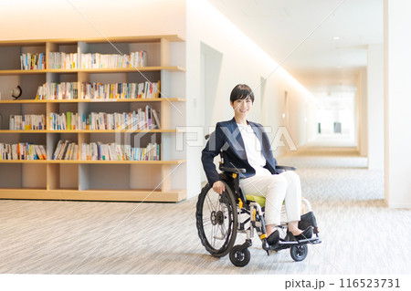 図書館で車椅子に乗っている若い女性 図書館で車椅子に乗っている若い女性 116523731