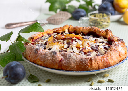 Open pie (galette) with plums and cardamom. Open pie (galette) with plums and cardamom. 116524254