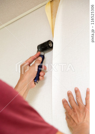 中古住宅のリフォームでクロスを張る職人 116525306