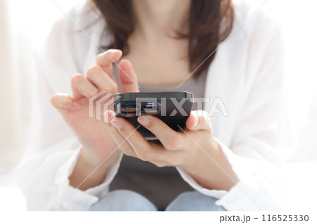 スマホを使う女性の手元 116525330
