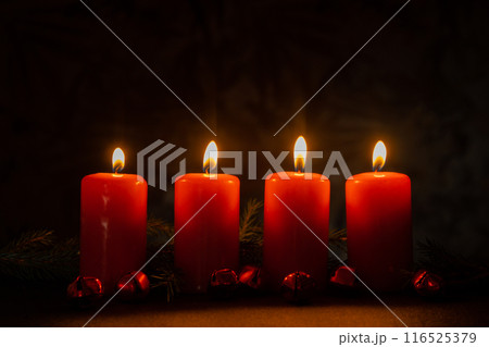 New year and Christmas preparation. Four red advent candles burning in dark room. Handmade eco-friendly decor. Sustainable Christmas decoration New year and Christmas preparation. Four red advent candles burning in dark room. Handmade eco-friendly decor. Sustainable Christmas decoration 116525379