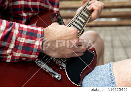 A man plays a beautiful guitar close-up A man plays a beautiful guitar close-up 116525493