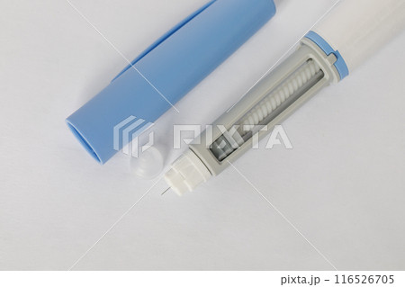 Self injection pen macro. Blue injection pen close up top view. Medicine and treatment concept Self injection pen macro. Blue injection pen close up top view. Medicine and treatment concept 116526705