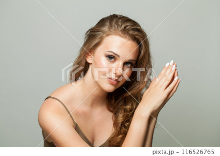 Young female face. Woman with makeup, curly hairstyle and fresh skin on white background 116526765