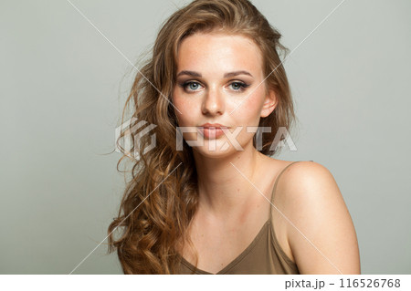 Pretty female face. Woman with makeup, curly hairstyle and fresh skin on white background 116526768