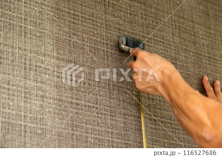 中古住宅のリフォームでクロスを張る職人 116527686