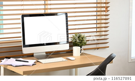 Blank screen desktop computer, coffee cup, documents and houseplant on wooden table 116527891