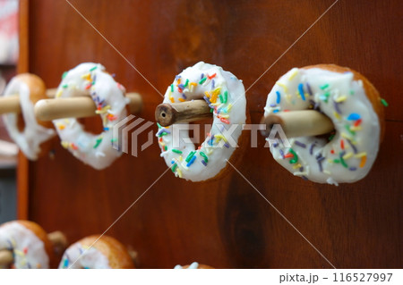 Donuts with colorful sprinkles on a wooden background. Selective focus. Donuts with colorful sprinkles on a wooden background. Selective focus. 116527997