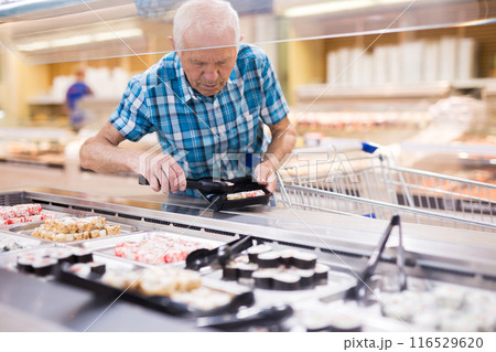 Mature senor puts in tray sushi in supermarket Mature senor puts in tray sushi in supermarket 116529620