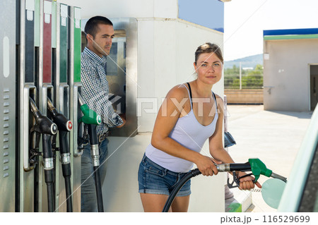 Woman filling up tank of her car with gasoline 116529699
