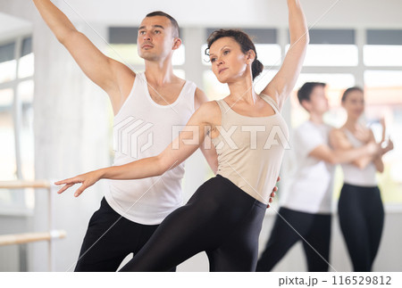 Ballet partners mastering paired technique at group class in studio 116529812