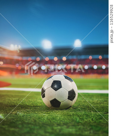 a soccer ball on green field with blur stadium at background 116529928