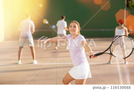 Woman serving ball during frontenis game outdoors Woman serving ball during frontenis game outdoors 116530088