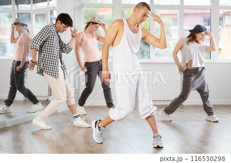 Young guy practicing hip hop slide moves in training hall 116530298
