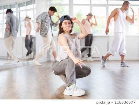 Young girl breakdancing against background of group members 116530377