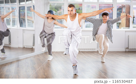 Young guy practicing hip hop reject step in training hall 116530487