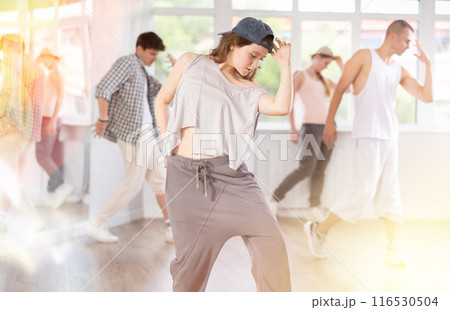 Young girl practicing hip hop slide moves in training hall 116530504