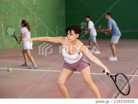 Woman serving ball during frontenis game outdoors 116530505