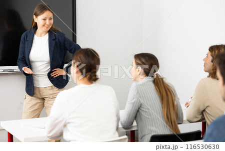 Knowledgeable female professor explaining subject to classroom full of students 116530630
