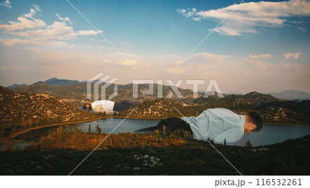 Contemporary art collage. Office workers lie collapsed over lake and rolling hills, symbolizing need for rest and escape from daily grind. 116532261