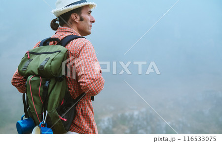 Man with backpack exploring foggy mountain landscape, embracing adventure in nature 116533075