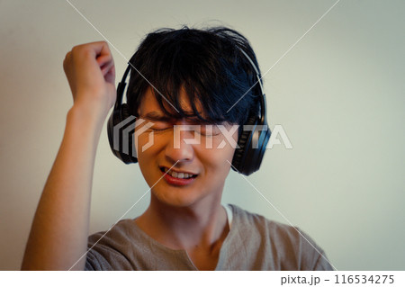 ヘッドホンで音楽に浸る若い男性 ヘッドホンで音楽に浸る若い男性 116534275