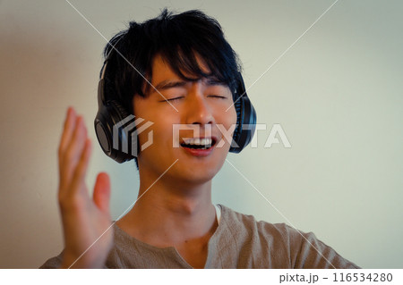 ヘッドホンで音楽に浸る若い男性 ヘッドホンで音楽に浸る若い男性 116534280
