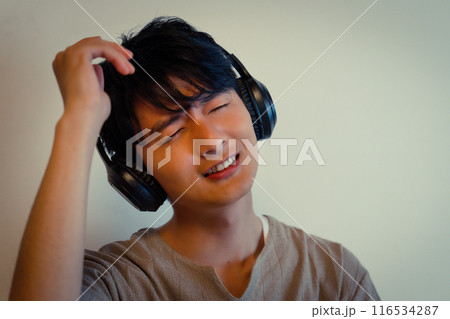ヘッドホンで音楽に浸る若い男性 ヘッドホンで音楽に浸る若い男性 116534287