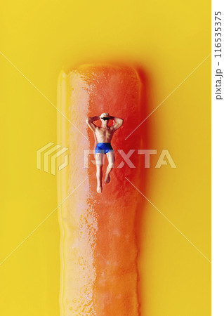 miniature man lying on a freeze pop 116535375