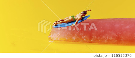 miniature surfer man on a freeze pop, banner 116535376