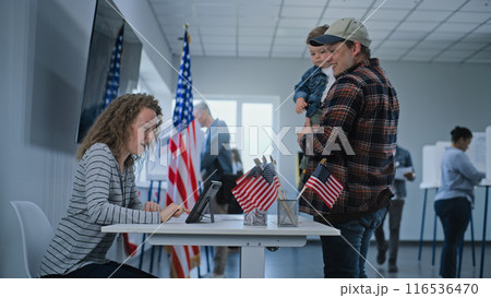 US citizen, male voter with kid comes to female polling officer US citizen, male voter with kid comes to female polling officer 116536470