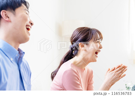 テレビを見て大爆笑するカップル テレビを見て大爆笑するカップル 116536783