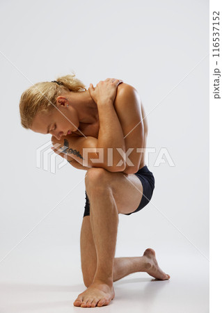 Young fit, shirtless man in black underwear posing, hug himself against white studio background. Selfcare. Young fit, shirtless man in black underwear posing, hug himself against white studio background. Selfcare. 116537152