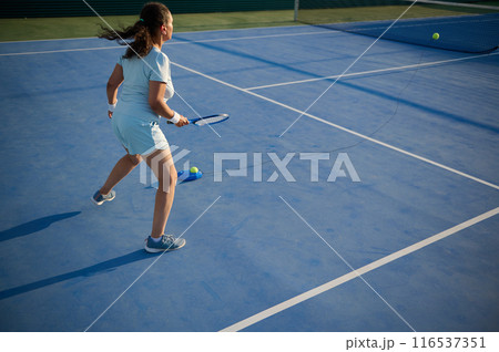 Woman plays tennis on the court 116537351