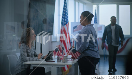 African American woman approaches registration table at polling station 116537666