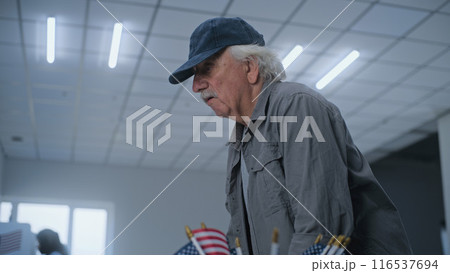 Caucasian elderly US citizen talks to polling officer 116537694