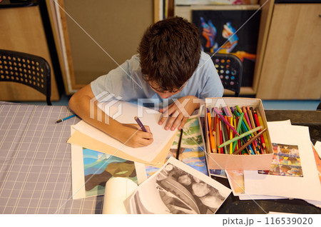 Child drawing and painting in art class with colorful pencils 116539020