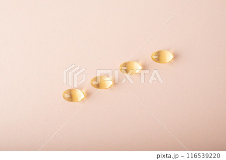 Omega 3 fish oil on pink background. Vitamins in soft capsules, cod liver oil closeup. Concept of healthcare, supplements, vitamin D, treatment. Copy space, top view, banner. High quality photo 116539220