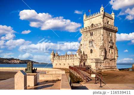 Landmark of Belem tower, Lisbon, Portugal at blue summer day sky with clouds. Medieval fortification on Tagus river in late Gothic or Manueline style, UNESCO world heritage site, Age of Discoveries 116539411