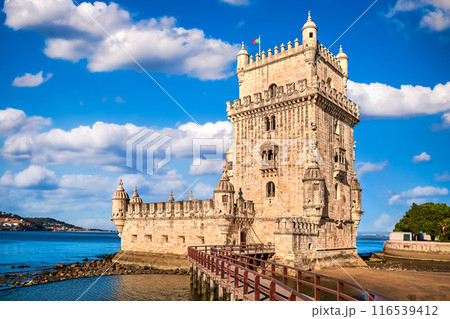 Belem tower and wooden bridge to it, Lisbon, Portugal at blue summer day sky with clouds. Medieval fort on Tagus river in late Gothic or Manueline style, UNESCO world heritage site, Age of Discoveries Belem tower and wooden bridge to it, Lisbon, Portugal at blue summer day sky with clouds. Medieval fort on Tagus river in late Gothic or Manueline style, UNESCO world heritage site, Age of Discoveries 116539412
