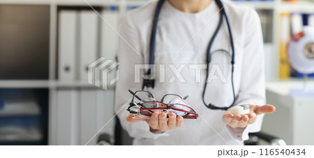 Female doctor making choice between contact lenses and glasses 116540434