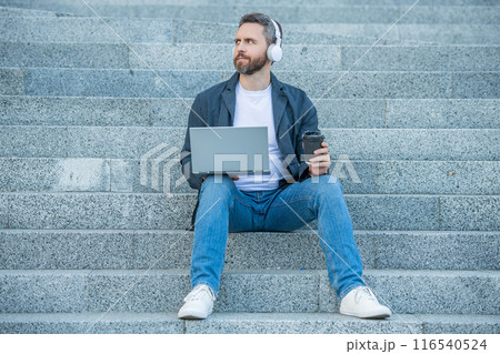 photo of man webinar online on laptop with coffee. man webinar online outdoor. photo of man webinar online on laptop with coffee. man webinar online outdoor. 116540524