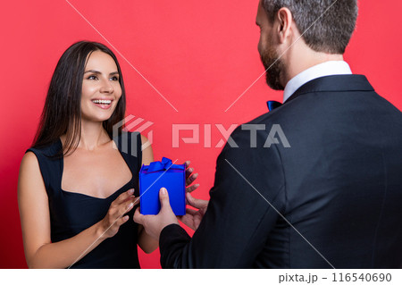 image of love couple with present box. love couple with present isolated on red. 116540690