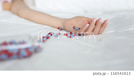 Young woman committing suicide by overdosing on medication Young woman committing suicide by overdosing on medication 116541013