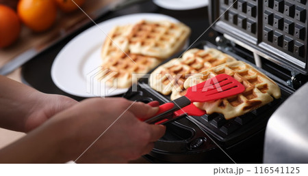 Waffle iron in kitchen, cooking homemade waffles Waffle iron in kitchen, cooking homemade waffles 116541125