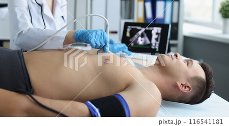 Doctor doing ultrasound of rib cage, cardiologist examining a patients heart 116541181