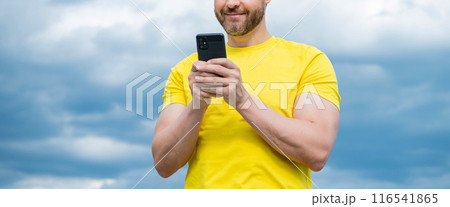 cropped view of man chatting on smartphone on sky background cropped view of man chatting on smartphone on sky background 116541865