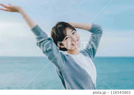 海を背景に背伸びする女性 116543003