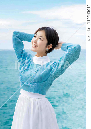 海を背景に背伸びする女性 116543013